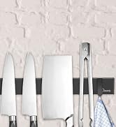 Kitchen knife set displayed on a white textured wall, including chef's knives, cleaver, and kitchen tongs.