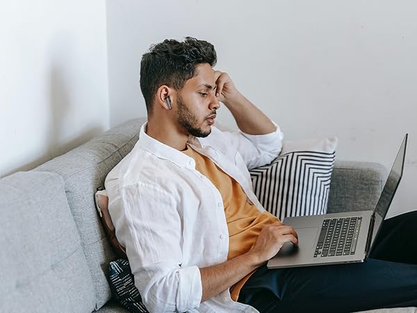 a man sitting on a couch with his head in his hand