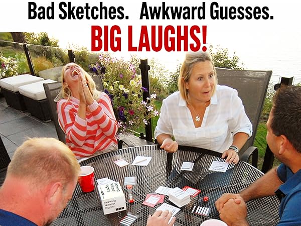 Adults laughing around a table with Drawing Without Dignty game spread out