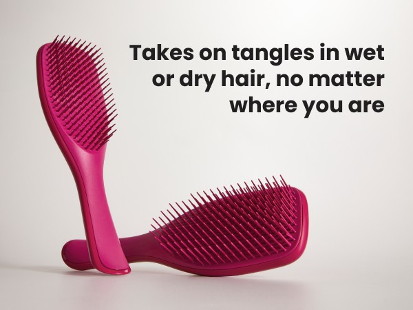 Two pink ultimate detangler brushes on top of a surface.