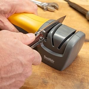 pocket knife being sharpening in handheld electric knife sharpener manual sharpening