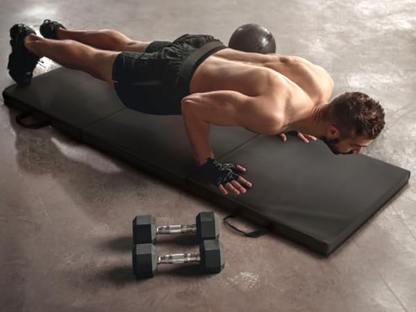 man doing push up in home gym with CAP exercise mat and dumbbells