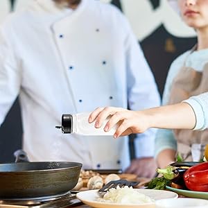 Chef adding salt to dish
