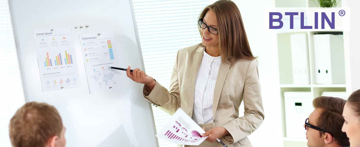A whiteboard displaying business charts and graphs with a person presenting the data while others observe in an office setting.