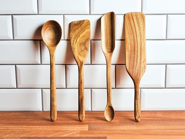 Four wood cooking utensils lined up against the wall