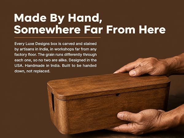 Hands finishing a solid mango wood cable box, showing carved grain and stain