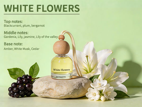 Text reads: 'WHITE FLOWERS' with fragrance notes layout. Product display showing white lily flowers, grapes, and a spherical perfume bottle on stone against green background.