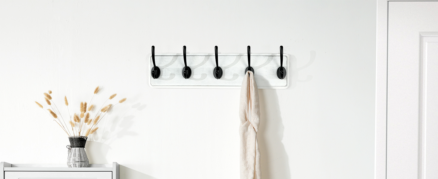 Next to the door is a weathered white wall-mounted coat rack