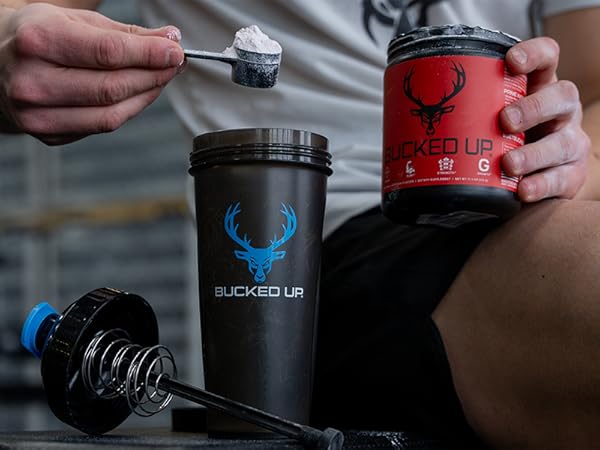 Man pouring scoop of Bucked Up Pre-workout into a Bucked Up Perfect Shaker bottle
