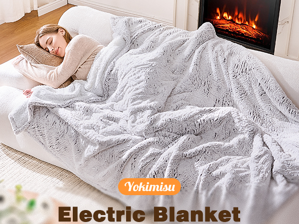 A lady lying on a couch with faux fur blanket on.