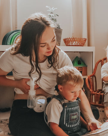 Mom pumping while reading a book to her son