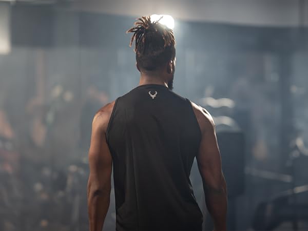 Man wearing Bucked Up tank top facing away from the camera in a gym