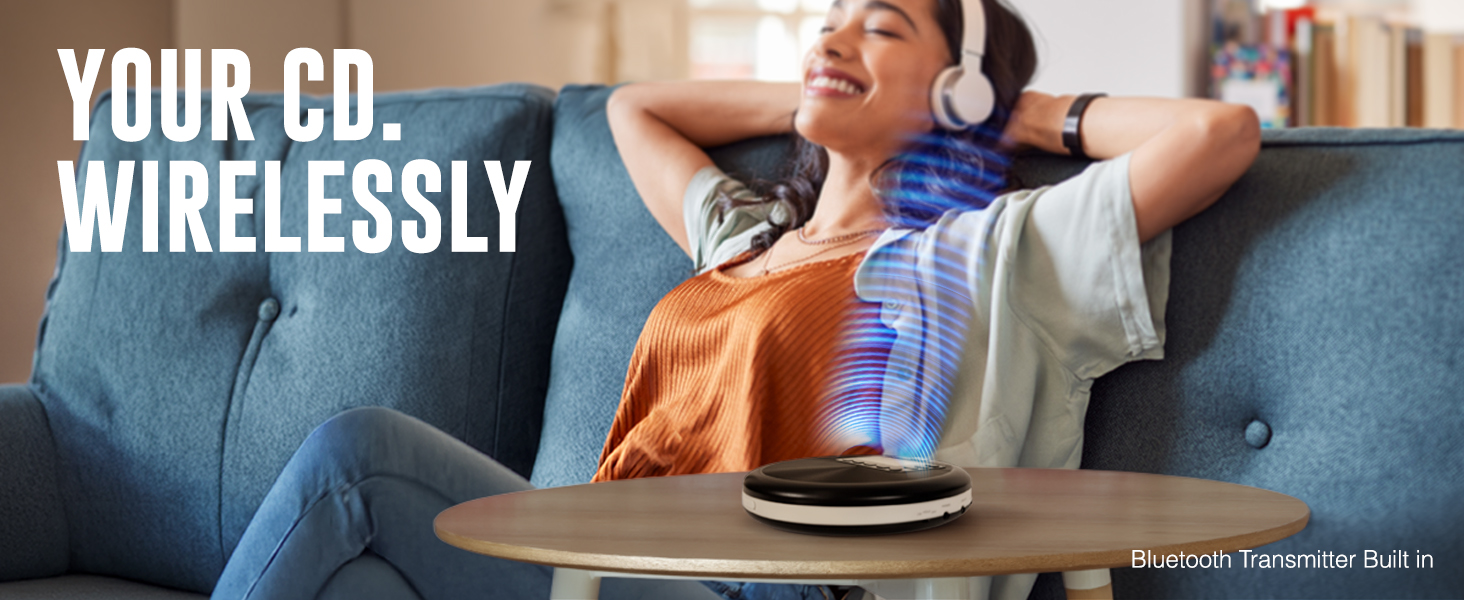 Woman wirelessly listening to the RETRO-30 CD Bluetooth player while relaxing on a couch.