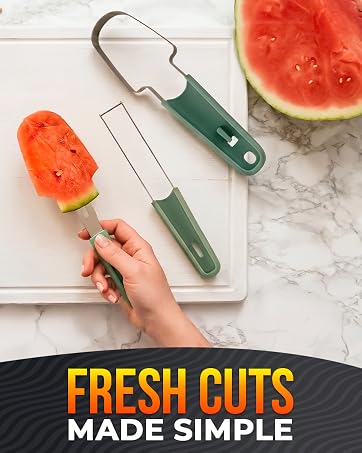 Green-handled watermelon cutter held in a hand lifts a red watermelon stick over a white board