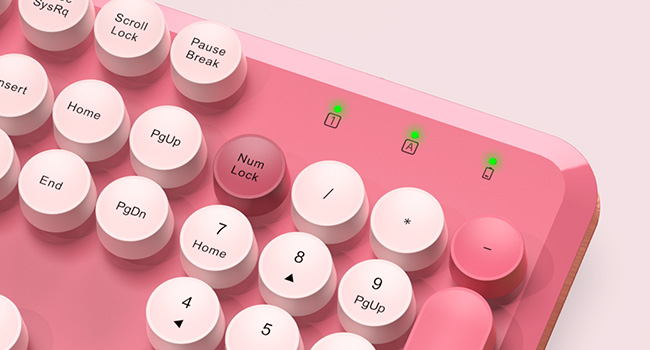 Close-up of the hot pink round-key keyboard showing the number pad and indicator lights.