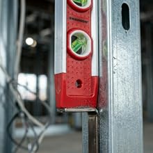 Close-up of magnetic strip holding level to metal stud