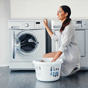 a woman cleaning a washing machine in a laundry room