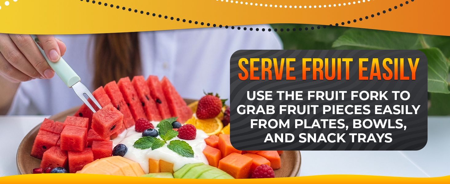 Green-handled fruit cutters fork spears a red watermelon cube above a bright mixed fruit platter