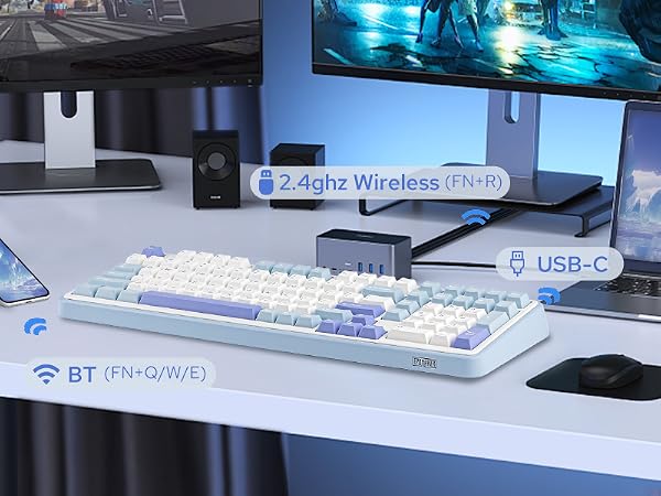 a white desk with a white keyboard, mouse, and two speakers.