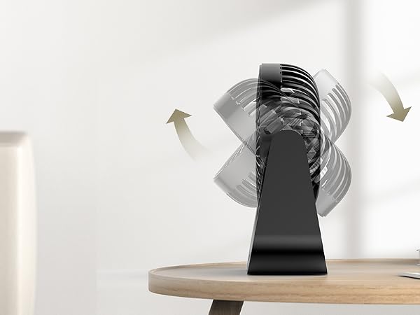 Black oscillating fan on wooden table in a living room setting, with arrows indicating air movement.