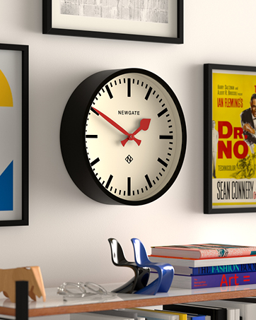 a black and white wall clock with a red hand on the face.