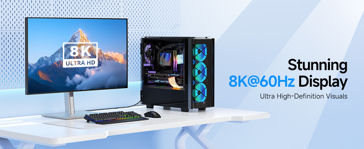 Gaming setup featuring a monitor display and RGB-lit desktop computer tower on a white desk surface.