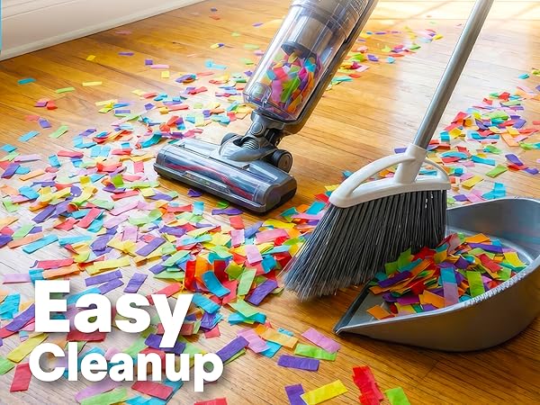 Easy cleanup of colorful confetti with vacuum cleaner, broom and dustpan on wooden floor