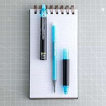 Photo shows deconstructed Frixion Synergy Clicker pen on a pad of paper