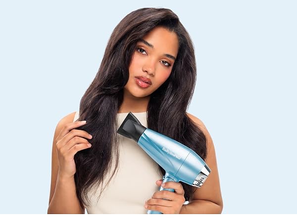 A woman holds the compact blue dryer beside her hair, highlighting ionic smoothing.