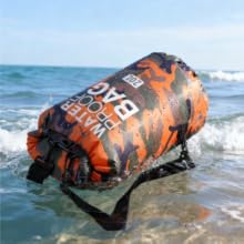 Waterproof dry bag floating in ocean for kayaking swimming and beach gear
