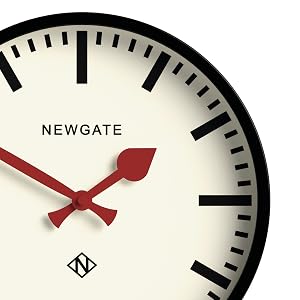 Newgate wall clock with cream-colored face, bold black hour markers, and distinctive red arrow-shaped hour and minute hands.