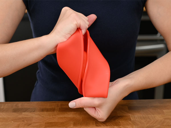 bending cake pan to show durability and longevity, unlike metal pans