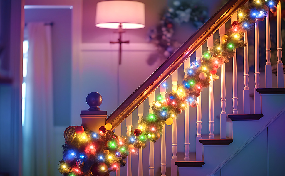 Wooden staircase decorated with multicolored Christmas string lights wrapped around white banister posts, creating a festive glow against blue and pink ambient lighting.