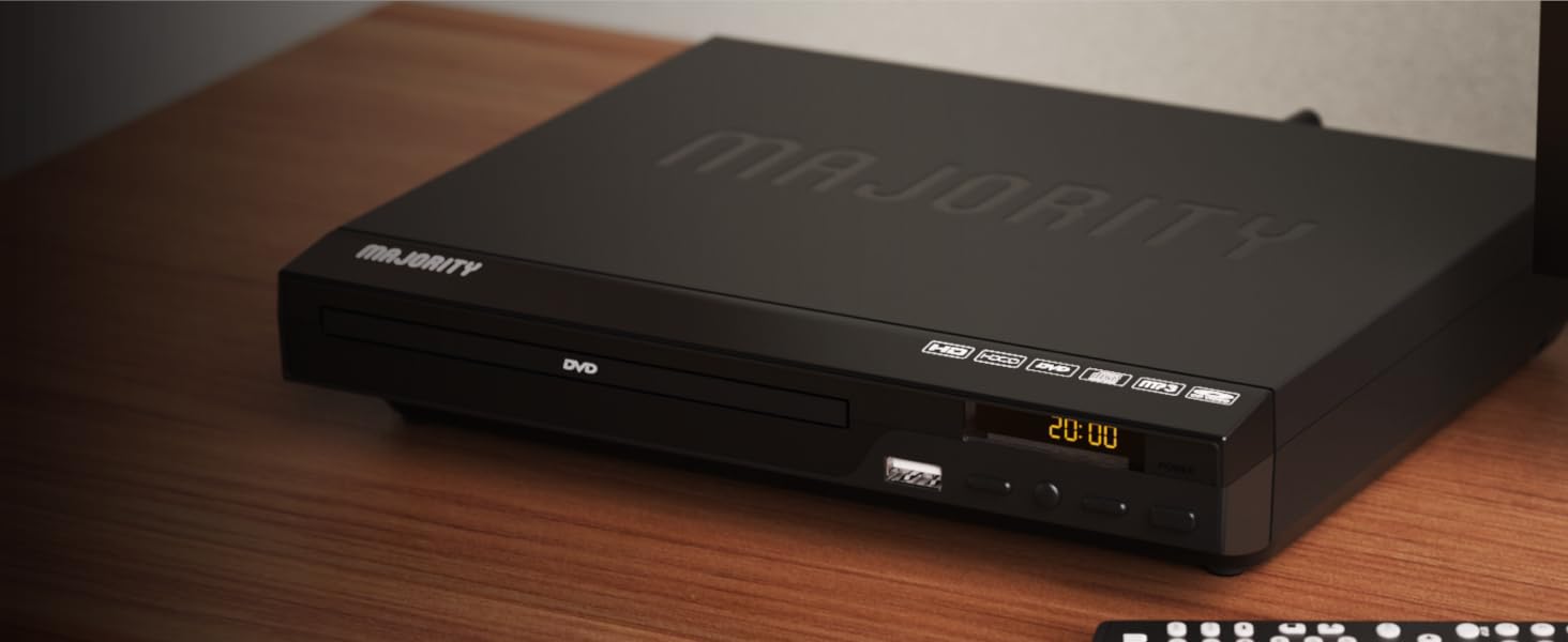 Majority region free dvd player on wooden shelf in living room. Display shows time