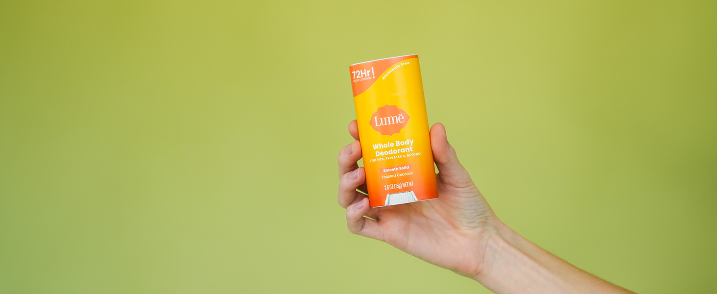 Lume Solid Stick Deodorant in Toasted Coconut being handheld