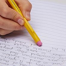 Yellow barrel pencil erasing words in notebook
