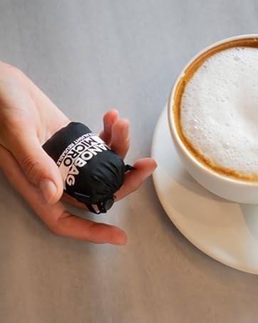 Nanobag Pouch next to a cup of coffee for size reference.