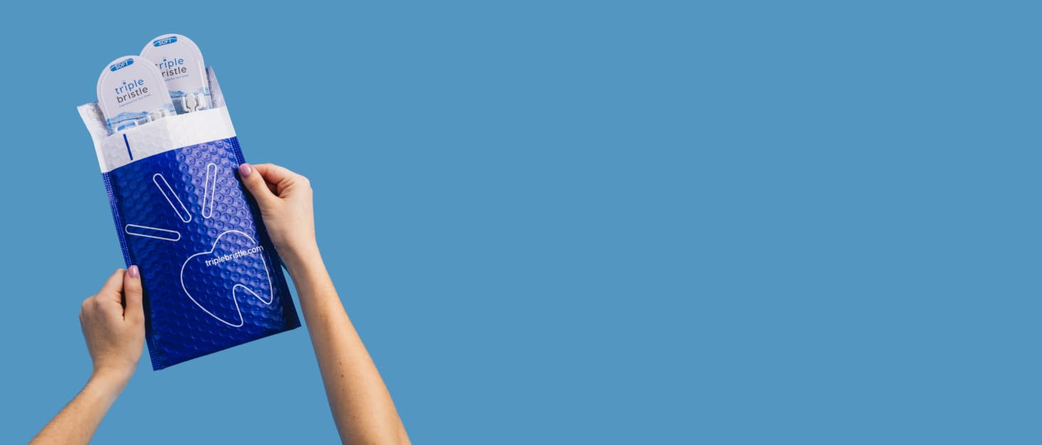 light blue background with person holding blue package triplebristle.com soft toothbrush heads