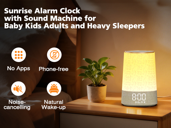 Text reads 'Sunrise Alarm Clock with Sound Machine for Baby Kids Adults and Heavy Sleepers'. Features icons showing 'No Apps', 'Phone-free', 'Noise-cancelling', 'Natural Wake-up'. Shows white lamp with warm yellow light and small plant.
