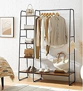 Black metal clothing rack with shelves, displaying clothes, bags, and shoes. Features hanging rod and multiple storage levels.