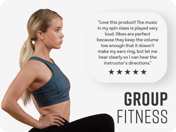 Woman working out in group fitness class wearing clear earplugs to tolerate loud noises in workout