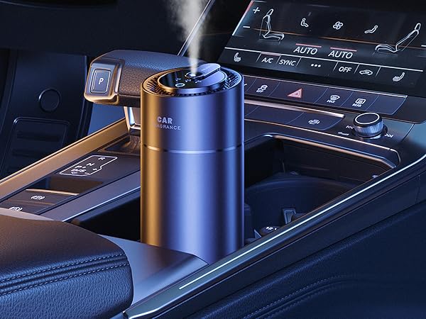 Metallic blue car humidifier or diffuser placed in vehicle cup holder, with mist emerging from top opening.
