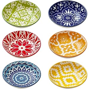 Collection of decorative plates featuring colorful floral and geometric patterns in blue, red, yellow, and green designs.