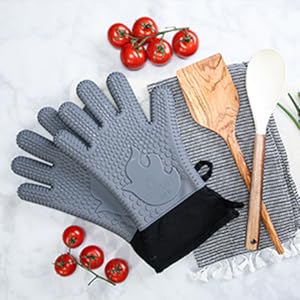 Gray gloves alongside kitchen utensils, tomatoes, and garlic – ready for cooking.