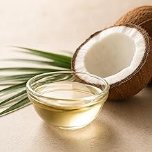 Coconut oil in glass bowl with halved coconut, showing lightweight, natural moisture source