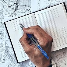 Photo shows person travel journaling with a G2 Extra Fine pen