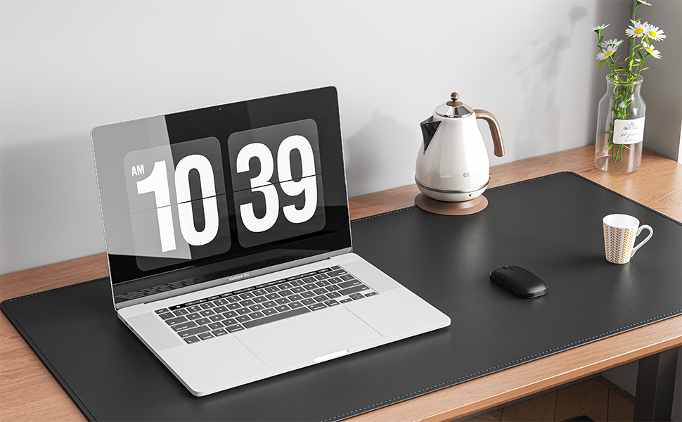 Laptop on desk displaying large digital clock reading 10:39. Desk setup includes electric kettle, mouse, mug, and small vase with flowers.