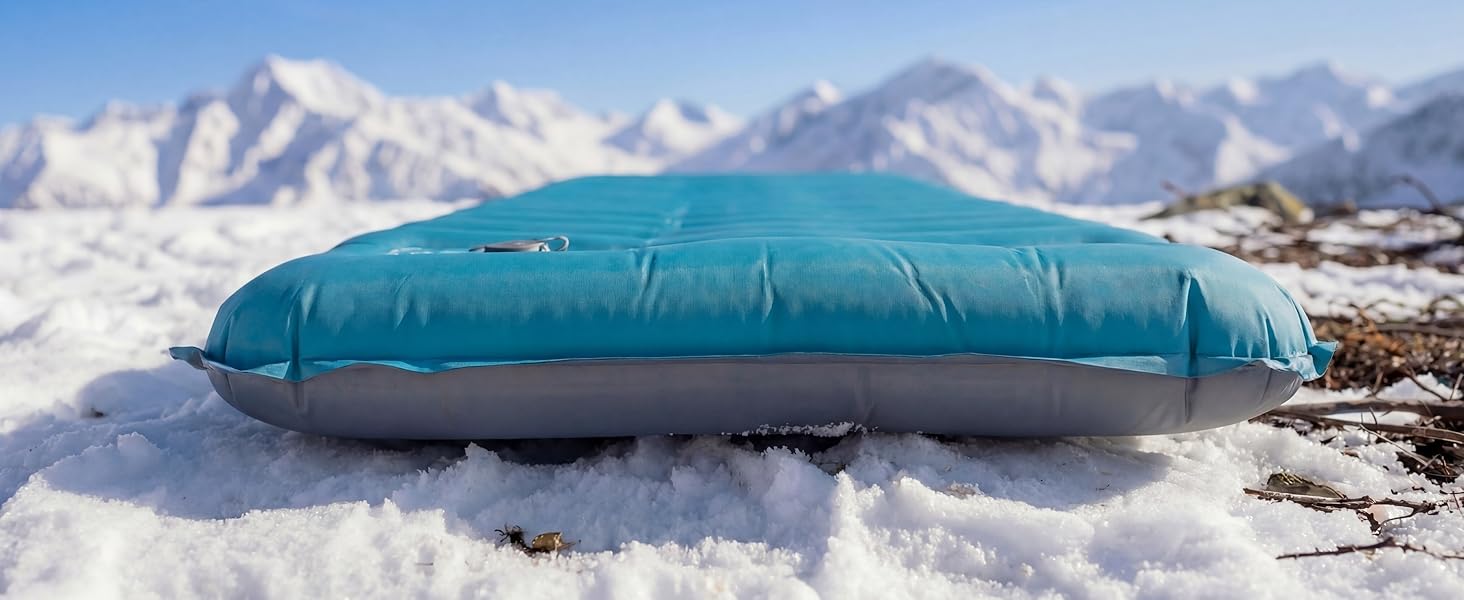 Airlive2000 sleeping pad on snow with mountain backdrop.