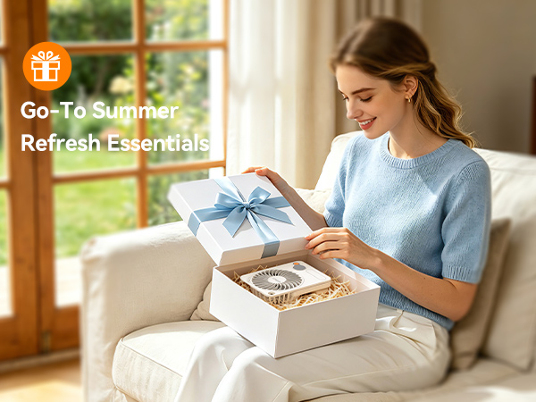 Text reads 'Go-To Summer Refresh Essentials' with orange circular logo. Woman in light blue t-shirt holding open product box with organized contents displayed, suggesting summer essentials collection packaging.