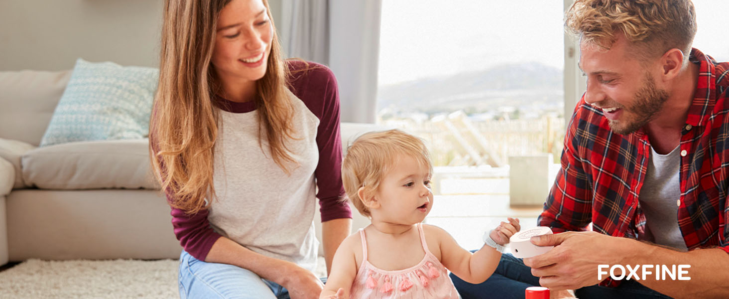 Parents and child playing with FOXFINE sound machine in living room